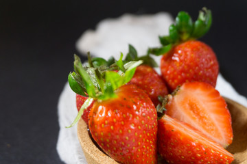 Strawberry on dark background with selective focus and crop fragment