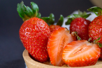 Strawberry on dark background with selective focus and crop fragment