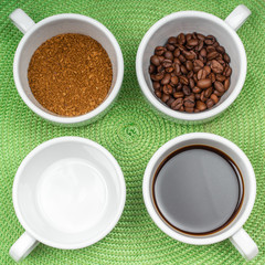 assortment of four white cups of coffee on a saucer grain, instant, brewed and an empty cup on the green background