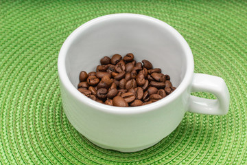white cup of grain coffee on a saucer, green circle background