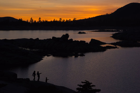 Kids Watching the Sunset by a Lake