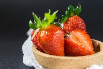 Strawberry on dark background with selective focus and crop fragment