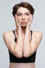 Emotional portrait of an anxious woman isolated on gray background.