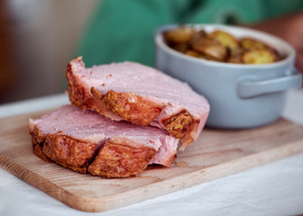 Frischer bayerischer Leberkäse und Breze aus dem Ofen mit Bratkartoffeln im Biergarten Wirtshaus zum Essen