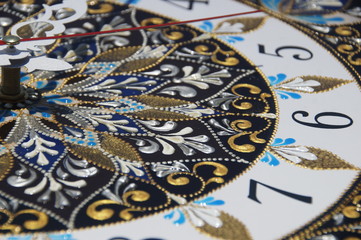 brown square hand-painted watch with contour acrylic paints in the technique point to point, with a geometric pattern in the form of a mandala, black numerals and white arrows