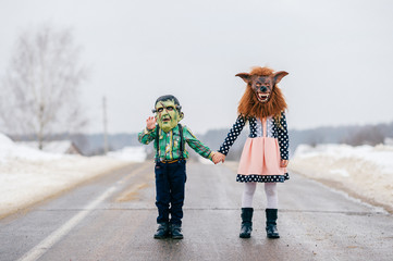Funny helloween children in creepy horror silicon masks portrait. Little comical kids with horrible...