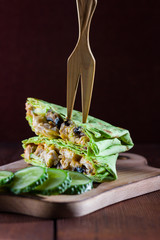 Sandwich. Green pita with chicken, mushrooms and cheese. Barbecue meat shawarma with cucumbers on wooden background. Pita with grilled meat. American cuisine. Copy space