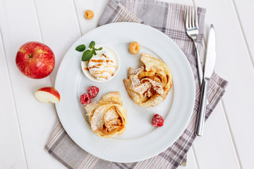 Crepes Pancakes with fruit jam and ice cream. Top view on white wooden table