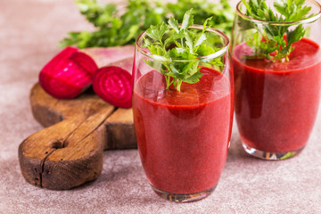 Bright beetroot smoothie in tumbler with fresh pieces of beet