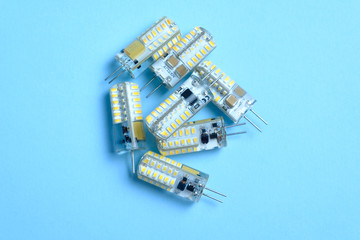 Several LED bulbs wound power isolated on a blue background. 220 watts and 12 watts. Light-emitting...