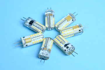Several LED bulbs wound power isolated on a blue background. 220 watts and 12 watts. Light-emitting...
