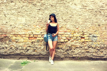 Beautiful young girl near the brick wall.