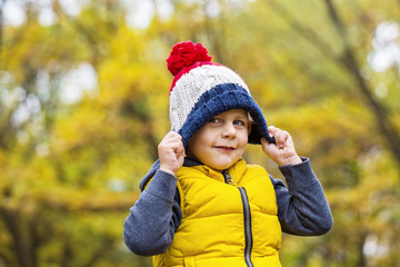 Little boy and fashionable warm knitted hat with a pompom