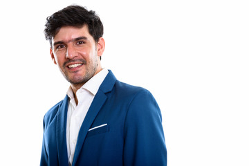 Studio shot of young happy Persian businessman smiling