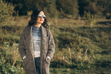 Pretty long hair bruntte girl walking in the autumn forest.