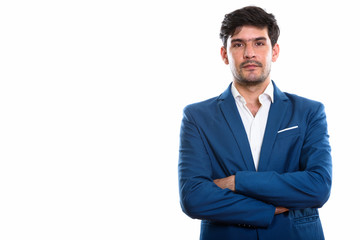 Studio shot of young Persian businessman with arms crossed