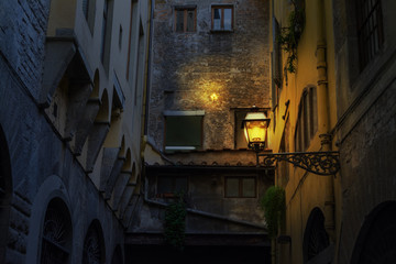 Illuminated lamp in a rustic corner in Florence at night