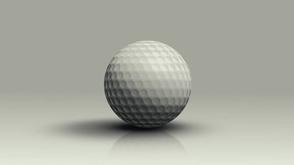 Golf ball rolls on the floor toward the camera and stops.