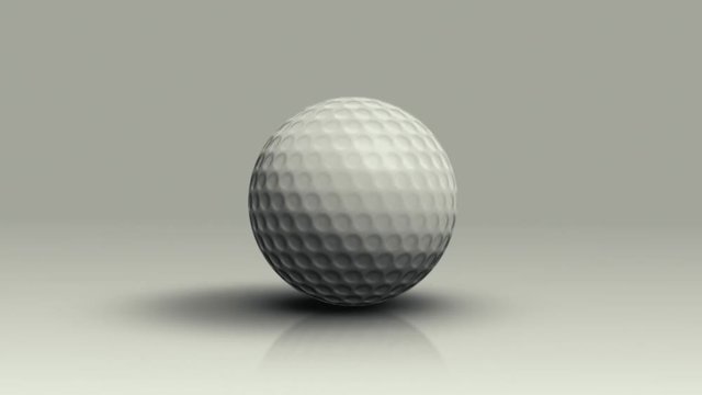 Golf ball rolls on the floor toward the camera and stops.