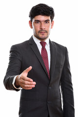 Studio shot of young Persian businessman giving handshake