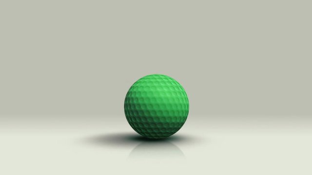 Green golf ball rolls toward the camera and stops.