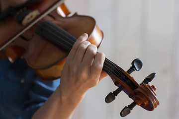 Girl playing the violin. Hand of a girl and a fiddle.