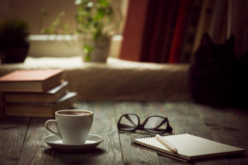 A cup of coffee in the workplace on a wooden table.