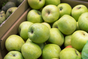 juicy green apples in a carton box are sold at the fruit shop. delicious ripe fruit. vegetable shop