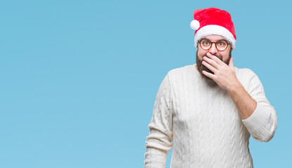 Young caucasian man wearing christmas hat and glasses over isolated background looking stressed and nervous with hands on mouth biting nails. Anxiety problem.