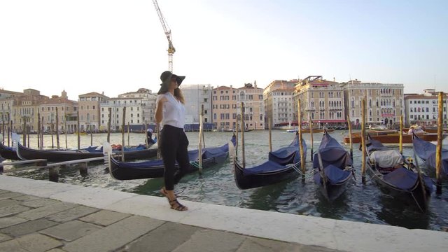Girl walking in venice near gondolas, Italy
