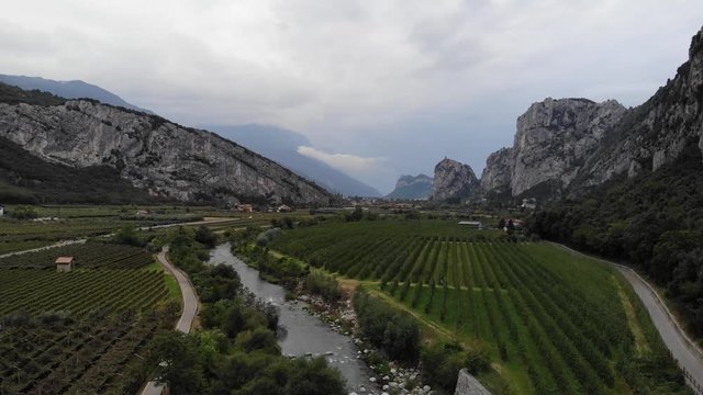 Hoher Flug &uuml;ber den Fluss Sarca und Weinreben in Richtung Arco bei Gewitterstimmung