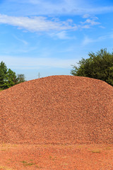 Bin of Red Clay Chips Medium Coarseness:  Bin of medium coarse red clay chips used for landscaping and driveways on display and for sale.
