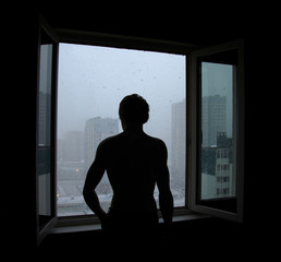 dark silhouette of a man near the window followed by snow