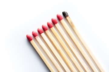 one burnt match with several unburnt matches
