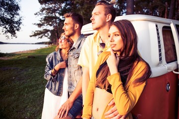 Cheerful young couple enjoying time together while leaning at their retro styled minivan