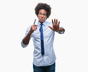 Afro american man holding credit card over isolated background with open hand doing stop sign with serious and confident expression, defense gesture