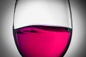 Red wine splash in the wineglass close-up macro texture background. Vintage old retro style view. Soft focus.