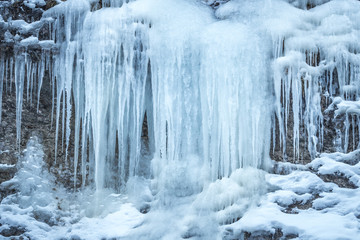 Fototapeta na wymiar Detail of a winter landscape, icefall on a rock wall.