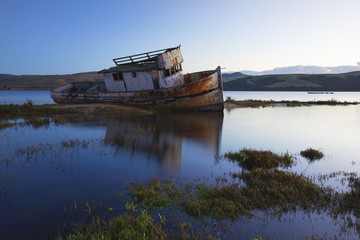 Fototapeta na wymiar Old boat shipwrecked in the murky waters