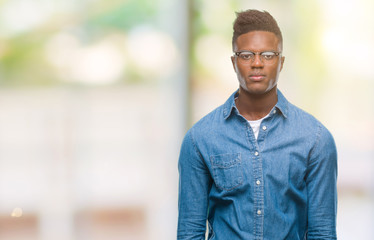 Fototapeta premium Young african american man over isolated background with serious expression on face. Simple and natural looking at the camera.
