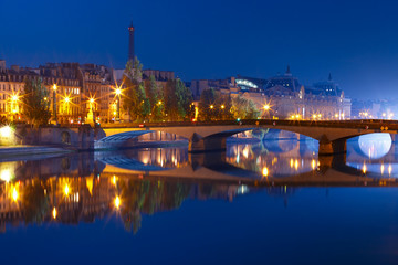Fototapeta na wymiar Beautiful view of Seine, Eiffel tower and bridge Pont Royal during morning blue hour in Paris, France