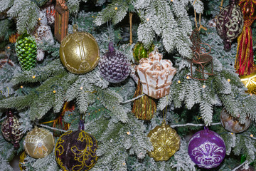 Christmas decorations and garlands on Christmas tree branches closeup
