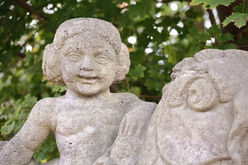 Stone figure, weathered, child on fish, detail, bridge town Hamm in Germany