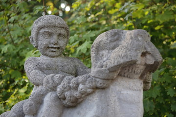Stone figure, weathered, child on seal, detail, bridge town Hamm in Germany