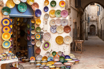 Morocco Essaouira colorful pottery dishes on display outside a shop located in a maze of pedestrian...