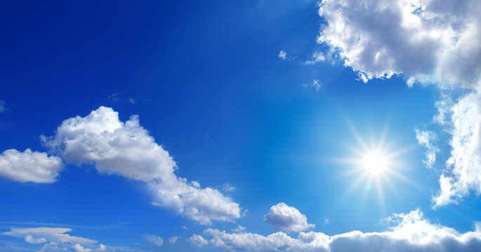conceptual background image of blue sky with clouds and shining sun
