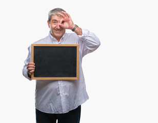 Handsome senior teacher man holding blackboard over isolated background with happy face smiling doing ok sign with hand on eye looking through fingers