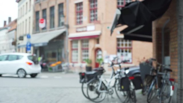 Blurry background plate of Bruges street corner with bicycles and store fronts