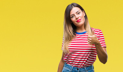Young beautiful woman casual look over isolated background doing happy thumbs up gesture with hand. Approving expression looking at the camera with showing success.