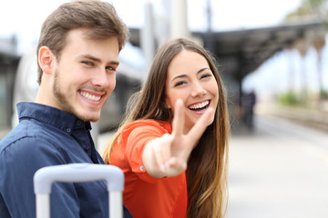 Couple of happy travelers posing in a train station